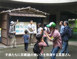 子供たちに双眼鏡の使い方を指導する栗原さん